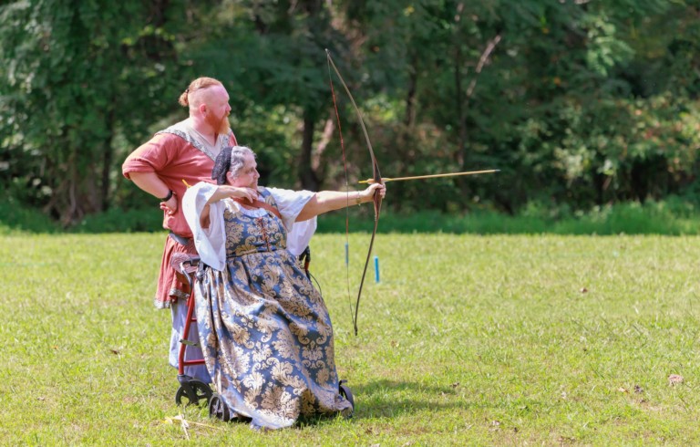 An archer, bow in hand, arrow loosed at their target